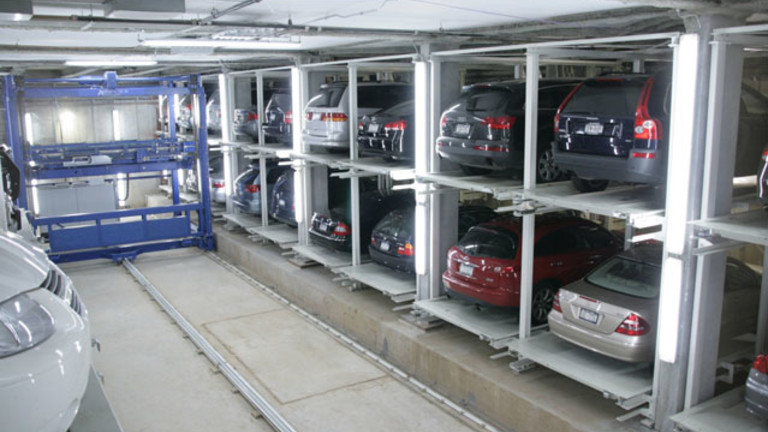Ansicht eines mit Fahrzeugen befüllten Regalblocks mit in der Mitte fahrendem Regalbediengerät.